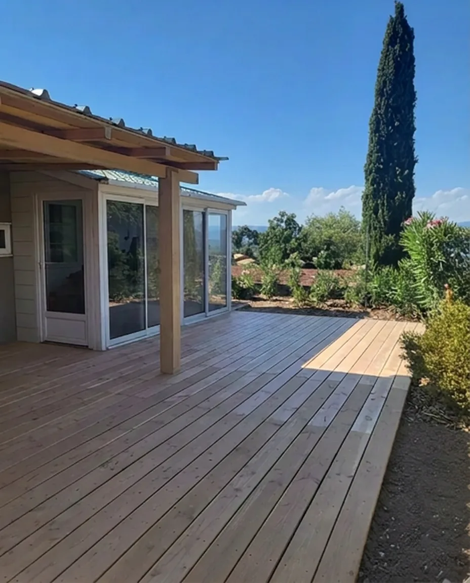 Terrasse en bois avec pergola, vue sur la vallée et un cyprès